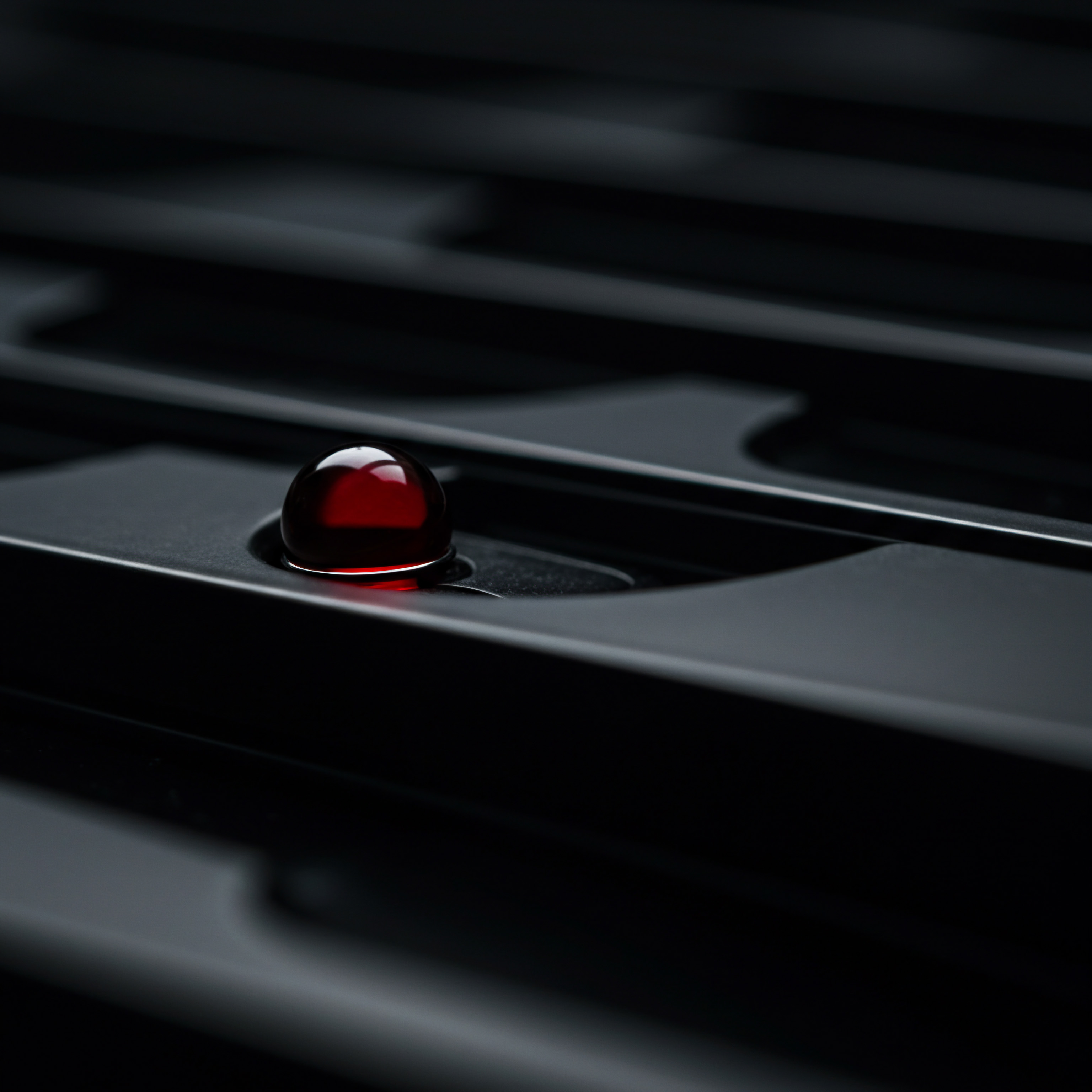 A Red Indicator Sphere on Black Surface Close Up Automation Strategy A close-up reveals a red sphere on a smooth, black surface. This image visualizes a technology-driven alert or indicator for businesses focusing on digital transformation. The red dot might represent automation software, the successful achievement of business goals or data analytics offering a critical insight that enables growth and innovation.