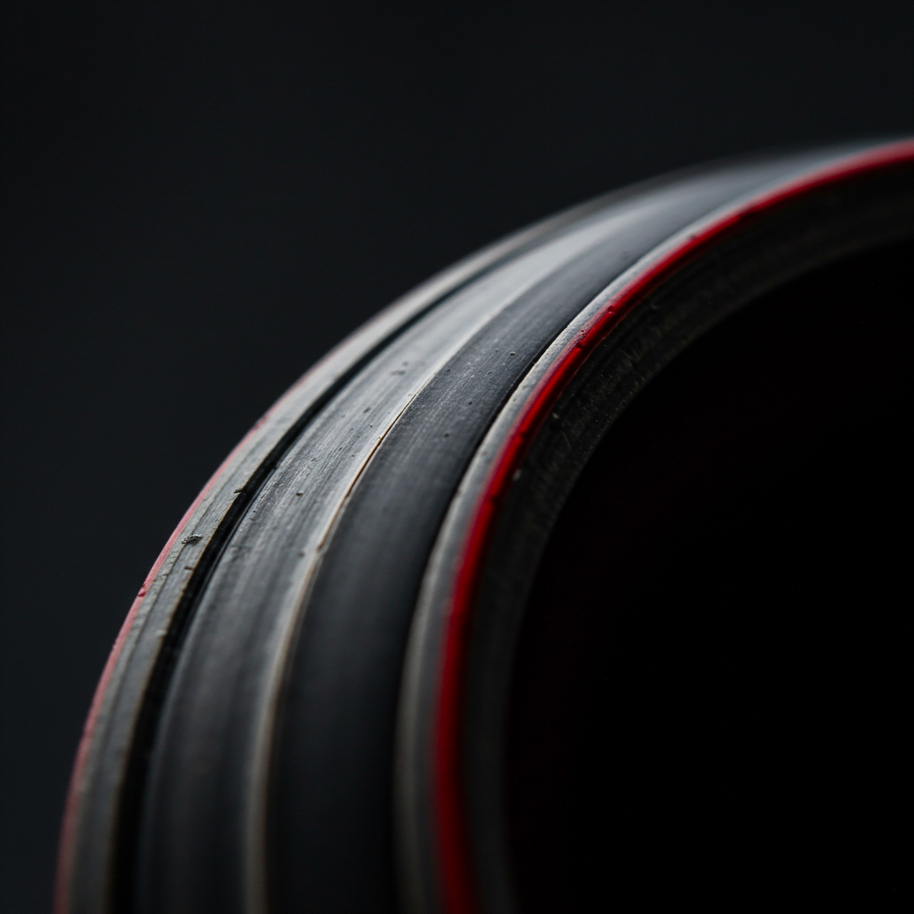 Black Product Ring Focus on Smooth Design for Small Business Promotion Focusing on a segment of a smooth black circular product edged with red set on dark background. It emphasizes streamlined productivity and optimization within Small Business workflows, representing enterprise class design and technological innovation for Business Owners. Representing solutions designed for Entrepreneurs embracing digital transformation and professional services, the smooth ring hints at seamless Customer service.