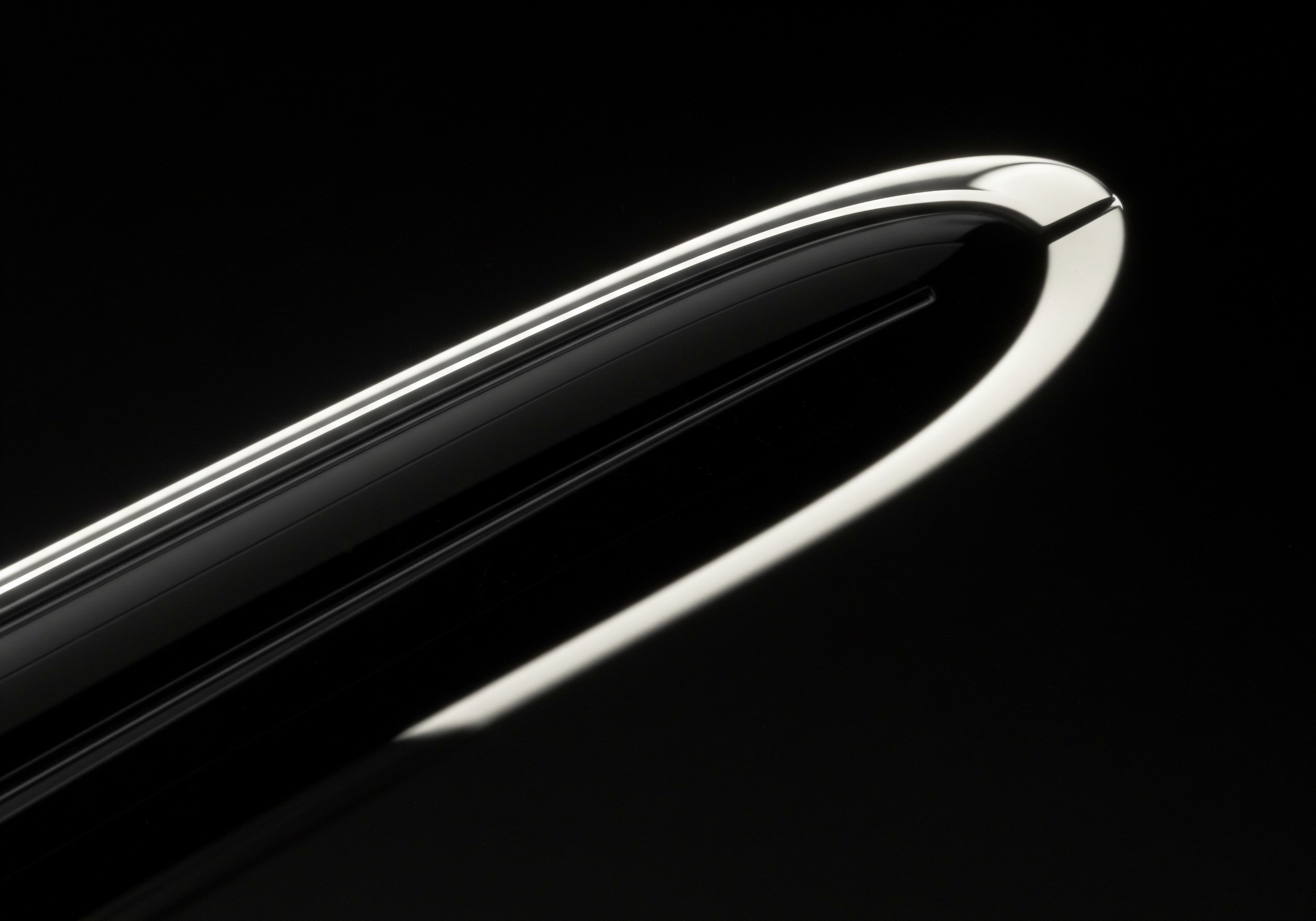 Close Up Image Of A Modern Elegant Object Suggesting Business Improvement Strategy The image depicts a reflective piece against black. It subtly embodies key aspects of a small business on the rise such as innovation, streamlining operations and optimization within digital space. The sleek curvature symbolizes an upward growth trajectory, progress towards achieving goals that drives financial success within enterprise.