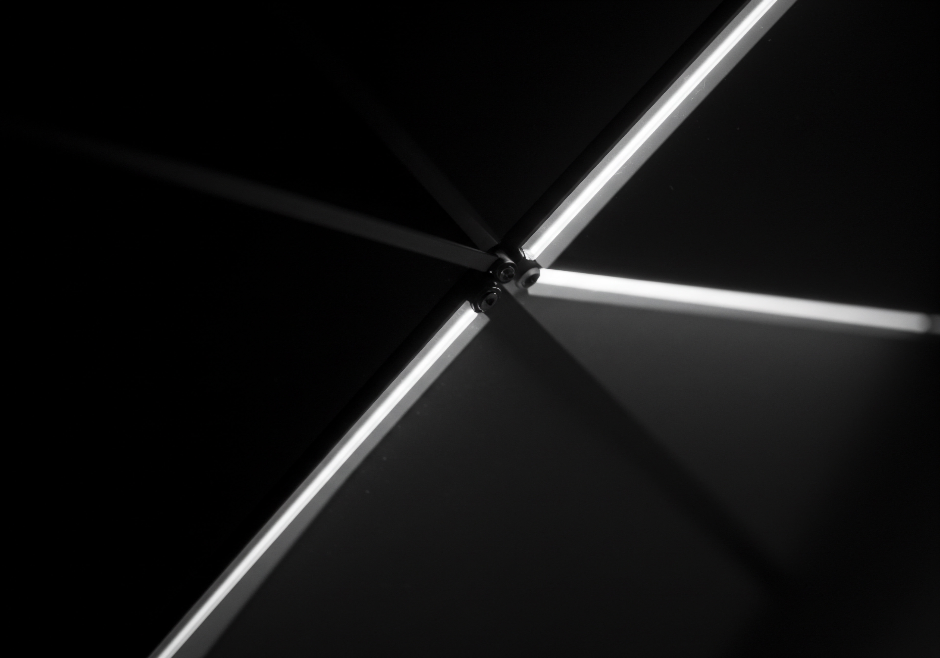 This grayscale photograph depicts a strikingly modern configuration where illuminated bars converge, creating an abstract representation of progress. The crisp lines and minimalist aesthetic evokes efficiency and precision essential for successful business ventures for small business entrepreneurs. Like a compass pointing towards growth, the intersection symbolizes strategy, business planning and optimization as a roadmap to success. The sleek digital tools and the focus on streamlining workflow underscore the importance of innovation and technology in scaling operations. The image embodies the values of scaling business with effective workflow automation providing entrepreneurs a potential pathway for expanding market share. The illumination symbolizes a business vision through growth hacking achieving ambitious business goals for a modern marketplace to enhance efficiency. Success emerges from intelligent optimization, reflecting business culture values while scaling business building towards the future.
