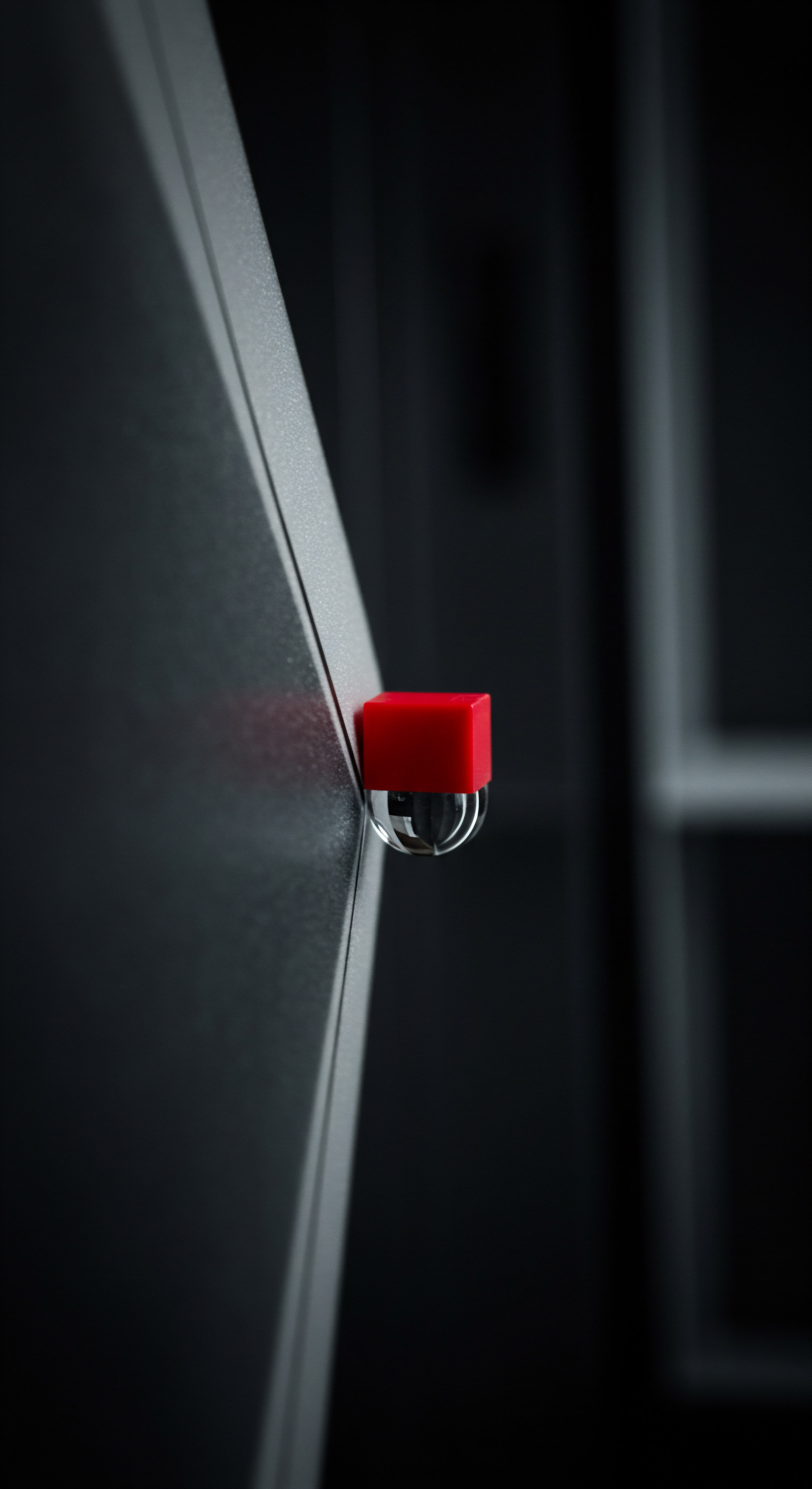 Red and Clear Security Alarm Detail for Small Business Workplace Growth Close up presents safety features on a gray surface within a shadowy office setting. Representing the need for security system planning phase, this captures solution for businesses as the hardware represents employee engagement in small and medium business or any local business to enhance business success and drive growth, offering operational efficiency. Blurry details hint at a scalable workplace fostering success within team dynamics for any growing company.