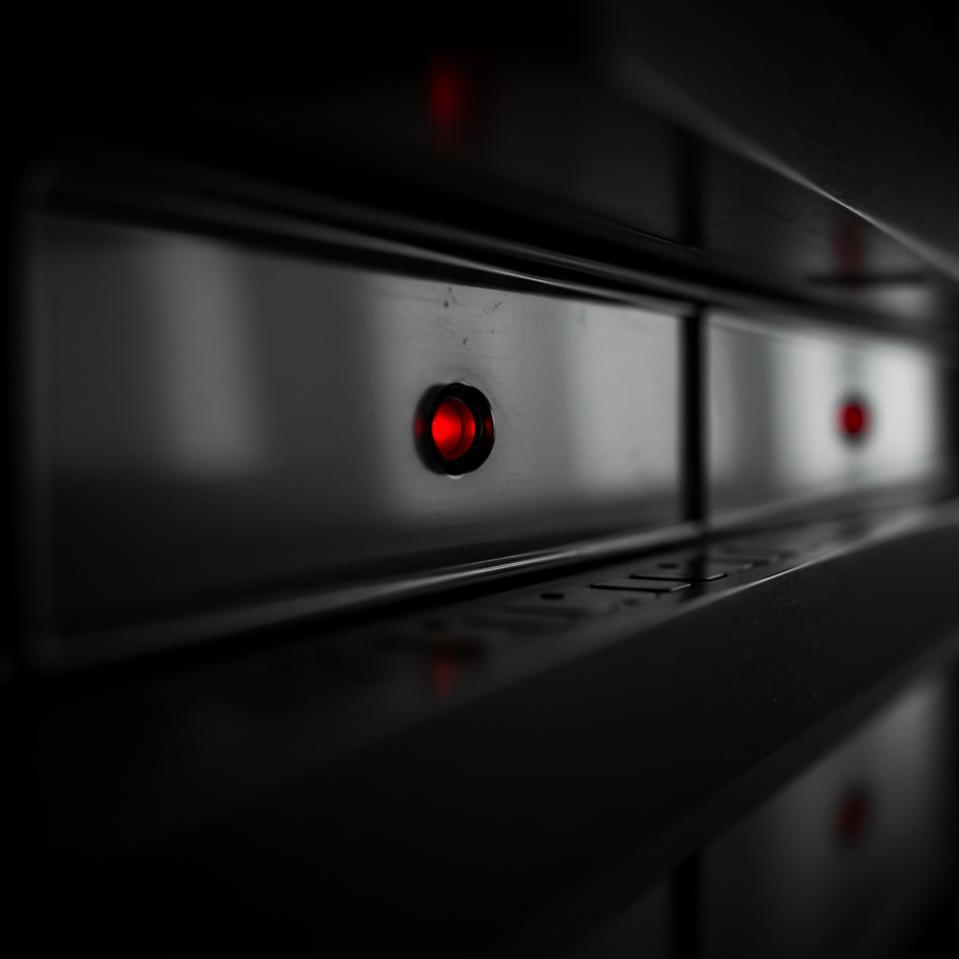 The close-up shot shows a bank of dark server drawers in an SMB data center, each featuring a small, glowing red light indicating operation. The dark setting with focus on a series of lights presents a glimpse into a technology powered small business infrastructure. This visual element implies underlying automation and system processes that propel growth through scalable service and solutions in digital marketing. Innovation and cutting edge business technology help drive productivity improvement using digital tools and cloud solutions like SaaS providing a competitive advantage and enabling operational efficiency.