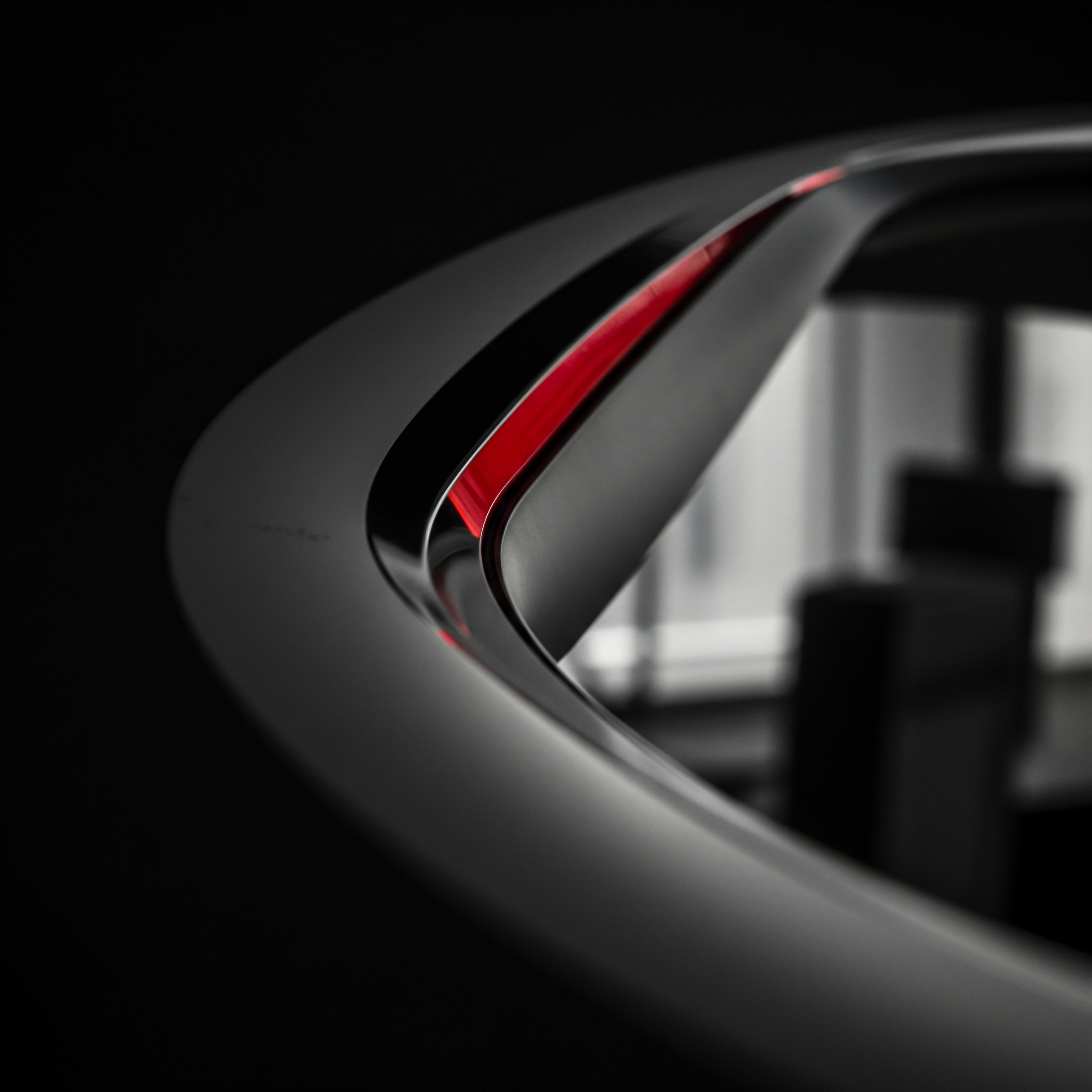 Sleek Business Technology for Medium Business Growth and Process Optimization The photograph displays modern workplace architecture with sleek dark lines and a subtle red accent, symbolizing innovation and ambition within a company. The out-of-focus background subtly hints at an office setting with a desk. Entrepreneurs scaling strategy involves planning business growth and digital transformation.